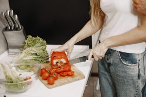 Mujer corta verduras frescas, representando la alimentación consciente y saludable.