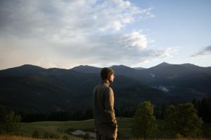 Hombre contemplando montañas, reflexionando sobre el desarrollo del autoconocimiento