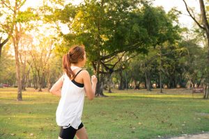 Mujer disfrutando de un estilo de vida activo y saludable al correr al aire libre. El ejercicio regular es parte de las recomendaciones del Ayurveda para promover el bienestar físico y mental.