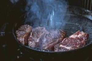 Carnes de res asándose en un asador, fuente de proteínas para una dieta equilibrada en la adolescencia.