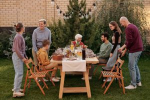 Fomenta el desarrollo personal y familiar con una imagen que muestra la unión de varias generaciones en una cena. Descubre cómo fortalecer los lazos familiares equilibra las necesidades individuales y colectivas.