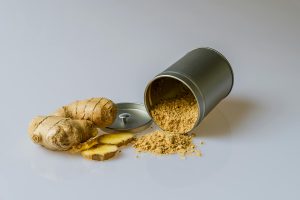 Imagen de jengibre fresco cortado y polvo de jengibre, ingredientes clave en la medicina alternativa japonesa conocidos por sus propiedades medicinales.