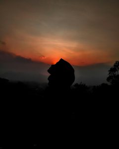 Una mujer se encuentra en la oscuridad, mirando hacia el cielo en busca de claridad durante la noche oscura del alma. Esta imagen evoca la sensación de esperanza y búsqueda de orientación en momentos de confusión espiritual. Representa el proceso de superación y transformación hacia la luz y el despertar interior.