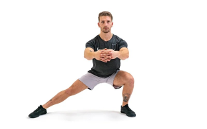 Persona realizando una zancada lateral con rotación de torso para mejorar la movilidad y estabilidad de las caderas