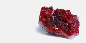 Imagen de un diamante granate rojo, cristal asociado al chakra raíz, que se cree ayuda a despejar bloqueos y restablecer el equilibrio.