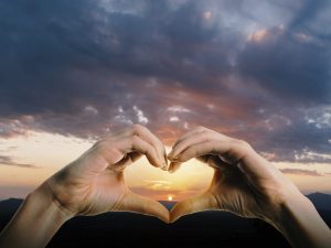 manos generando un corazón al cielo.