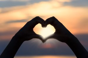 Figura creando un corazón hacia el sol. La meditación para la ansiedad, Bondad Amorosa puede ser muy potente en la búsqueda de la tranquilidad. 