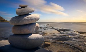 Pilas de piedras frente al mar, mostrando la serenidad que puedes encontrar con la meditación transcendental para la ansiedad.
