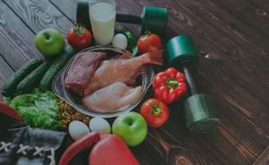 Alimentos saludables y pesas para hacer deporte. Nutrición y deporte para un estilo de vida activo y saludable.