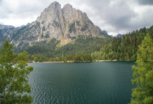 Paisaje del Parque Nacional de Aigüestortes i Estany de Sant Maurici en España, con un lago, bosques y montañas.