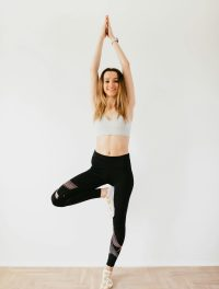 Mujer realiza la postura del árbol.