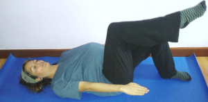 Imagen de una mujer embarazada practicando levantamiento de piernas en una clase de Pilates para embarazadas.