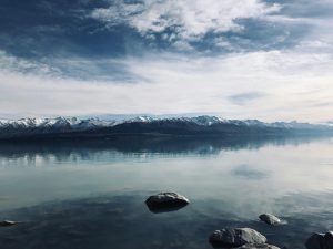 Impresionante vista de un lago tranquilo cubierto por nubes blancas en Pukaki, Canterbury, Nueva Zelanda.