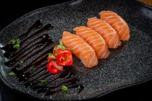 Imagen de cuatro porciones de salmón fresco cocinándose en una sartén, listas para ser disfrutadas como parte de una alimentación saludable durante el embarazo