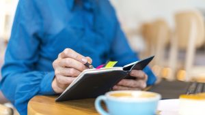 Imagen de una persona escribiendo en un cuaderno sus metas y objetivos de desarrollo personal.