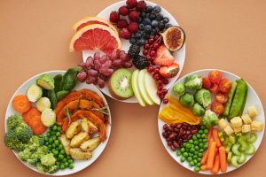 Platos con variedad de frutas y verduras ricas en vitaminas. Descubre cómo estas Vitaminas para el Cansancio Físico, Mental y Emocional pueden mejorar tu energía y bienestar.