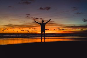 Silueta con los brazos abiertos en gratitud con el universo.