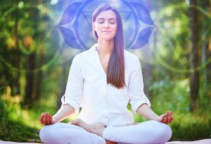 Mujer meditando con luz sobre su cabeza, representando la activación del chakra del tercer ojo y la conexión espiritual.