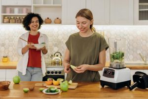 Mujer cortando frutas orgánicas en una mesa de cocina