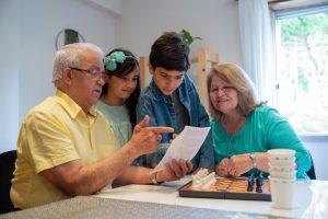 Un abuelo comparte sabiduría con su familia, fomentando el desarrollo personal y familiar a través de la comunicación y el aprendizaje conjunto.