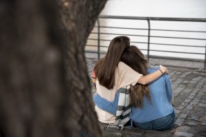 abrazo de amigas en momento dificil, establecer relaciones solidas para lograr un estado completo de bienestar físico, mental y social