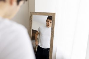 Persona frente al espejo, reflejando confianza en sí misma y fortaleza interior.