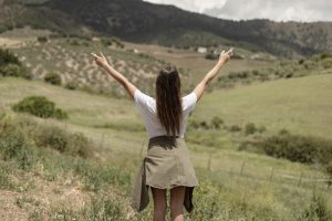 Persona escribiendo en un diario de gratitud, rodeada de objetos que simbolizan la abundancia y la felicidad. Fomentando la espiritualidad como medio de desarrollo humano.