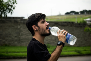 Persona bebiendo agua para mantener un estilo de vida saludable.
