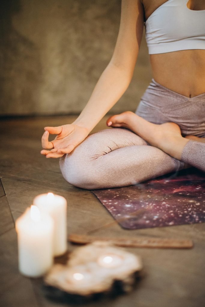 Imagen de meditación con velas: una persona medita en posición relajada, mostrando calma y equilibrio. Perfecto para explorar diferentes meditaciones.
