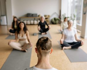 Instructor de meditación guiada con estudiantes en postura de meditación.