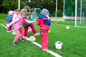 Imagen de niños practicando fútbol, resaltando la importancia de la actividad fisica en la salud y el desarrollo infantil.
