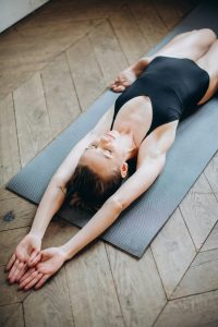 Una joven practicante de yoga se relaja en la postura del héroe reclinado, Supta Virasana.