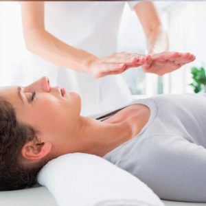 sesión de Reiki, una antigua técnica japonesa que busca equilibrar la energía del cuerpo a través de suaves toques y posiciones de las manos, promoviendo así la relajación y la curación.