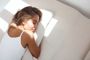 Una mujer duerme plácidamente en una escena que evoca el descanso profundo gracias al mindfulness.