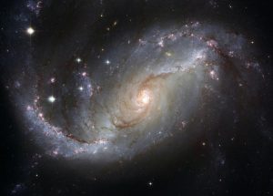 Imagen del espacio estelar con galaxias y estrellas, representando la vastedad y la interconexión del cosmos y sus elementos.
